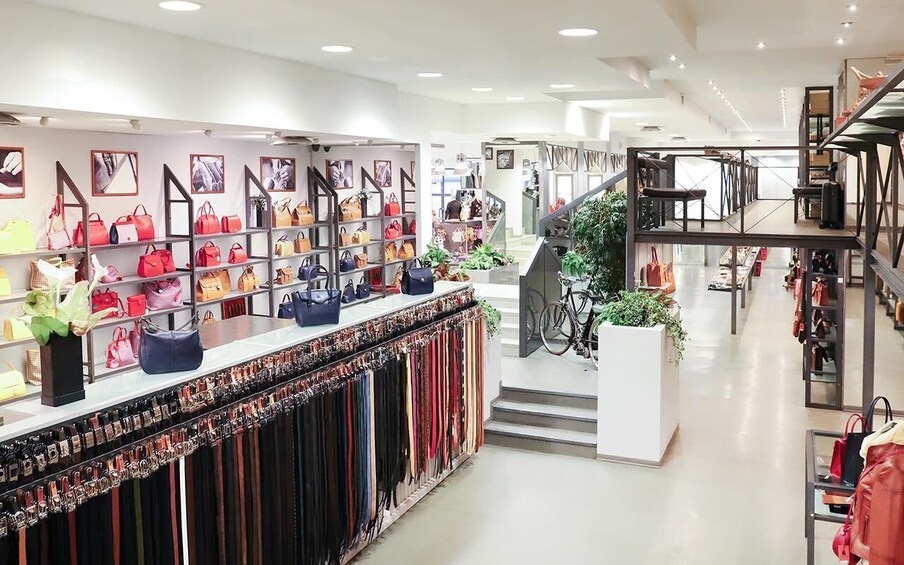 A modern retail store with multiple levels, featuring handbags and accessories on display. 5