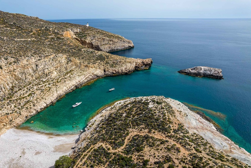A coastal landscape with rocky cliffs, a lighthouse, and clear turquoise waters. 3