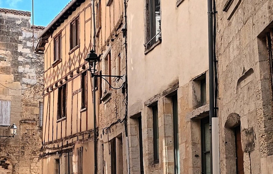 A historic building with exposed wooden beams, a stone wall, and a street lamp. 3