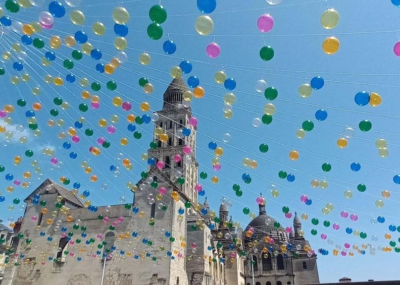 A historic building with a bell tower and dome, decorated with multicolored balloons. 4