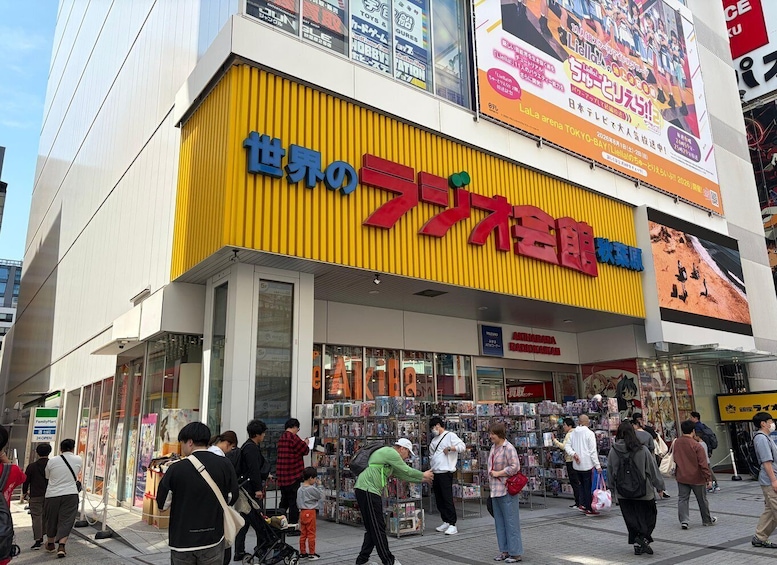 A busy street with a prominent yellow building featuring a large red sign. 2