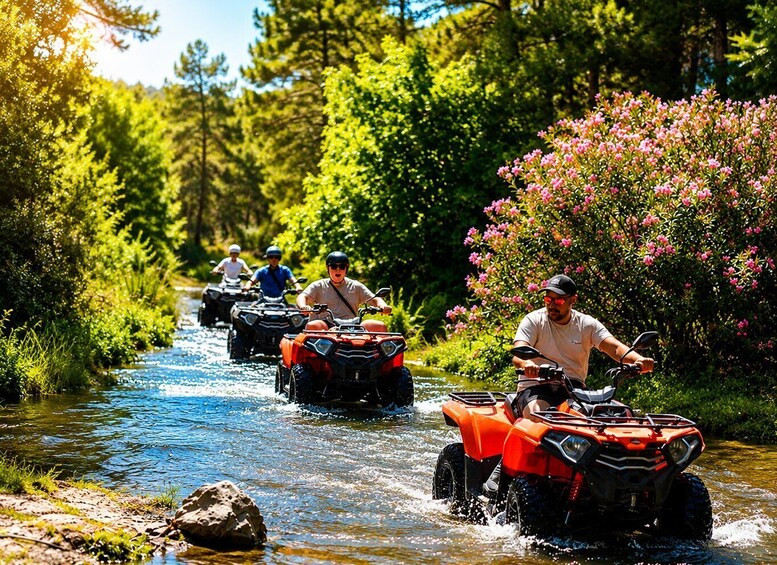 People riding ATVs on a river surrounded by greenery. 1