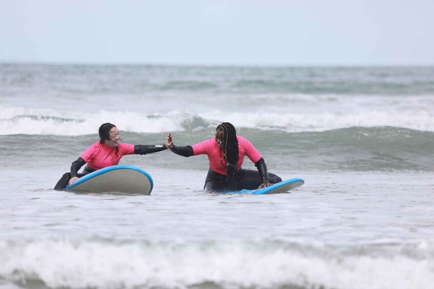 Two people on surfboards in the ocean. 4