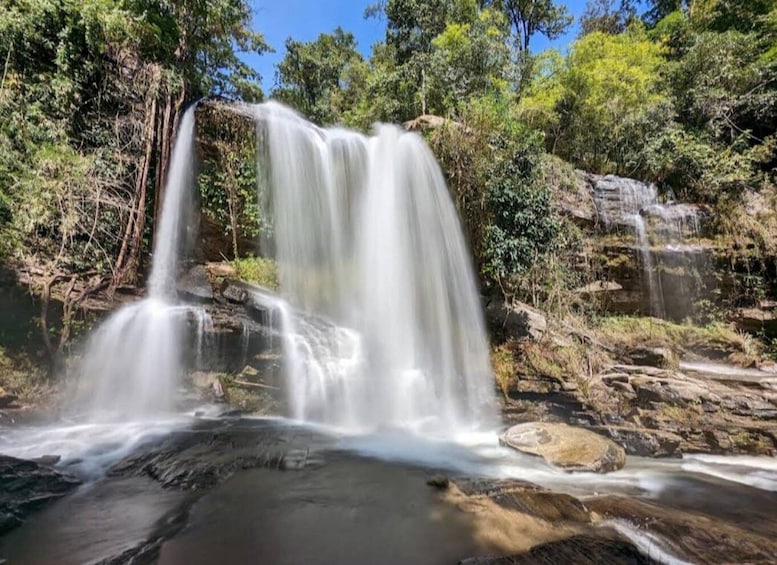 A waterfall cascading over rocks in a forested area. 5