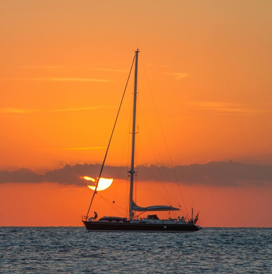 A sailboat on the ocean during sunset. 4