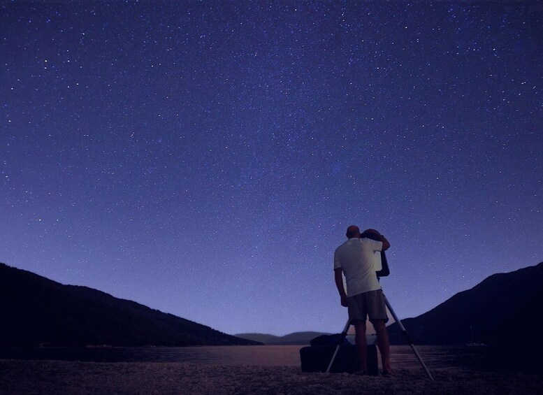 A person standing on a beach under a starry night sky. 3