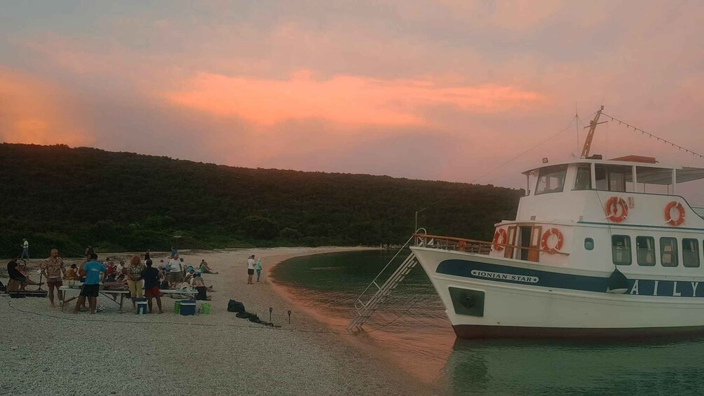 A boat named 'IONIAN STAR' docked at a beach with people gathered on the shore. 4