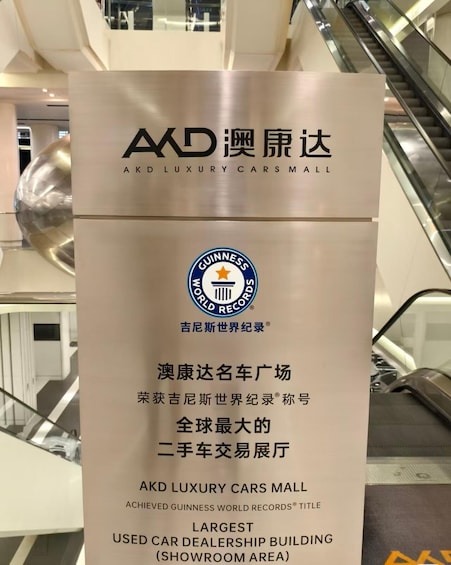 A sign for AKD Luxury Cars Mall with Guinness World Records title for the largest used car dealership building showroom area. 3