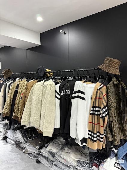 A clothing store with racks of jackets and bags. 5
