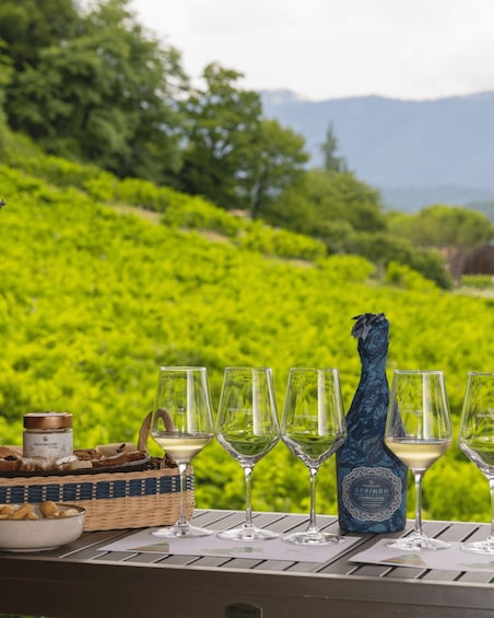 A table with wine glasses, a bottle of Manzone wine, and a basket of snacks. 4