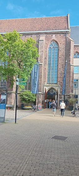 A historic building with a tiled roof, large arched windows, and a brick facade. 2