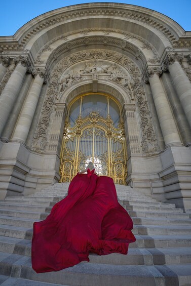 A grand building with ornate columns and a large golden door. 3