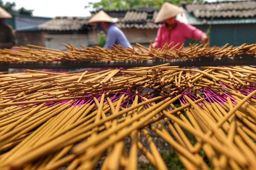 A person in a pink shirt working with bamboo sticks. 5