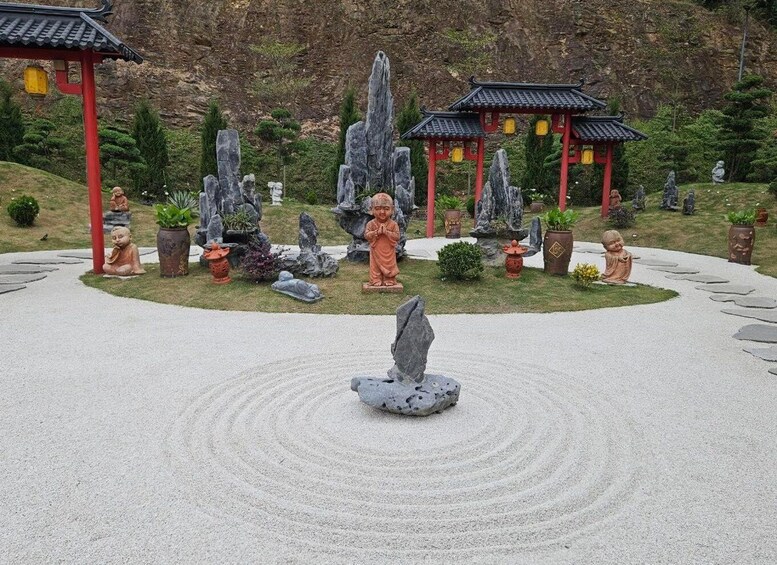 A Zen garden with a central rock fountain, surrounded by stone statues and traditional Chinese architecture. 3