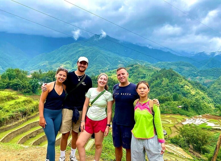 A group of people standing on a terraced hillside with a mountainous landscape in the background. 4