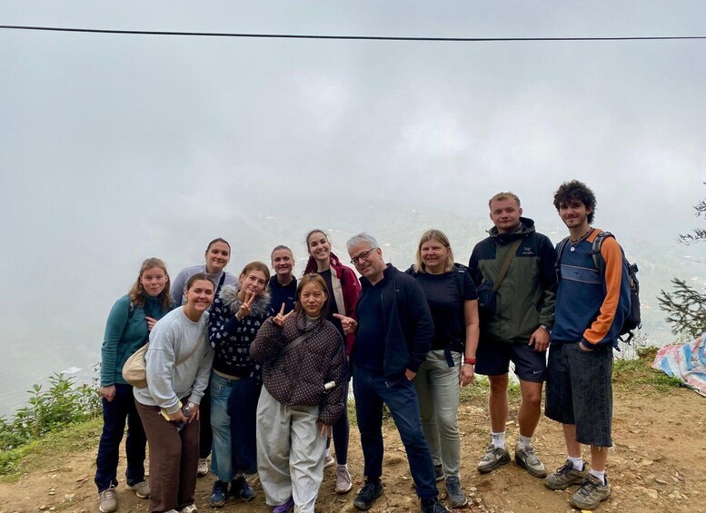 A group of people standing on a dirt path with a cloudy sky in the background. 5