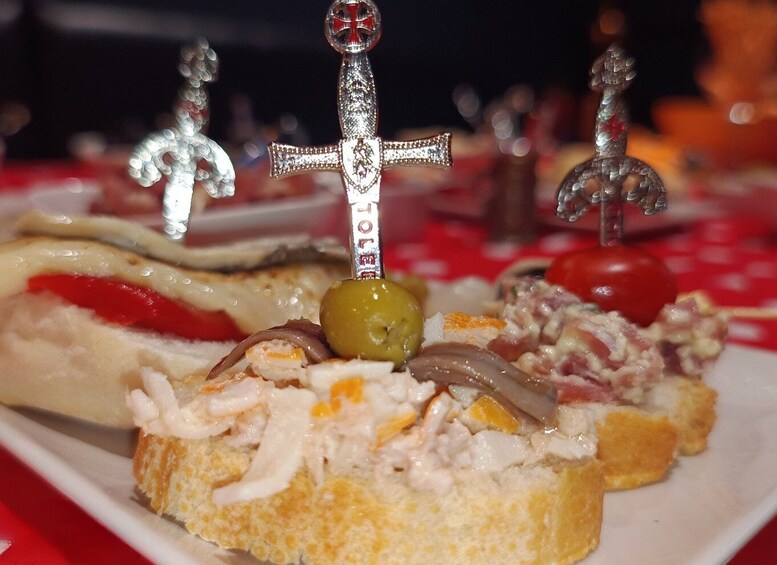 A plate of assorted appetizers with a decorative sword in the center. 5