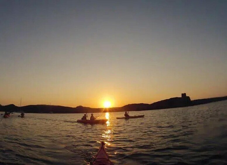 A sunset over a calm body of water with boats and a distant hill. 4