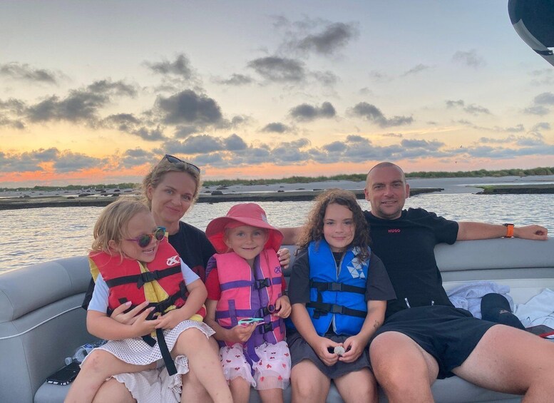 A family on a boat with a sunset in the background. 2