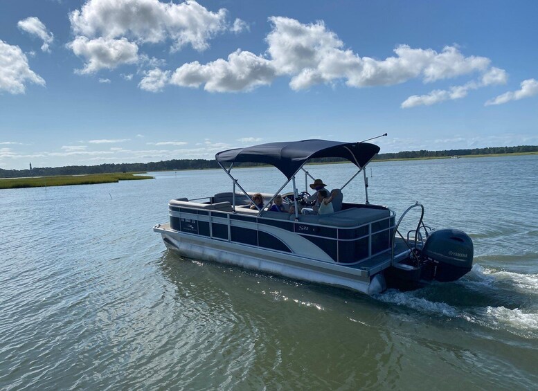 A boat with a canopy, people on board, and a calm water body with a clear sky. 5