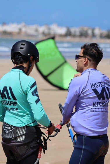 Two people on a beach with a kite in the background. 4