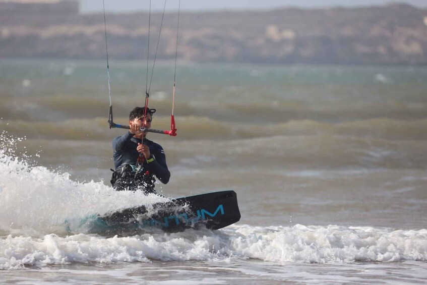 A person kiteboarding on a surfboard in the ocean. 5