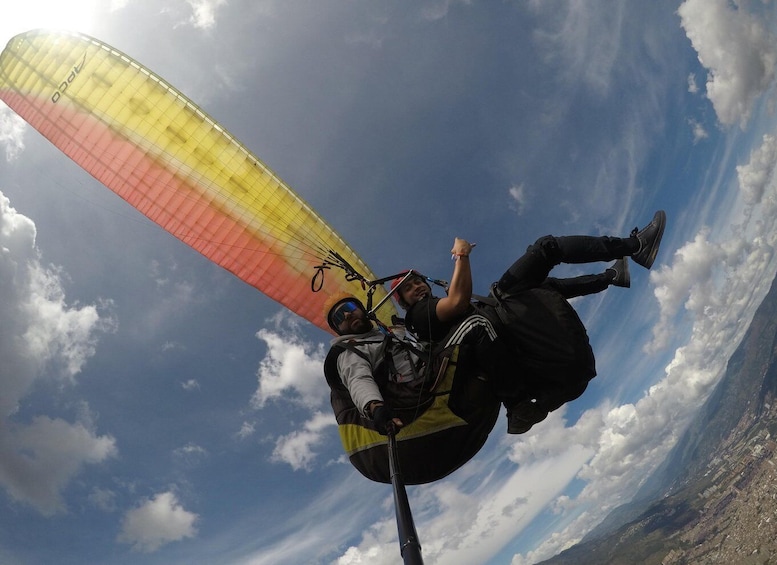 A person paragliding with a colorful parachute against a clear sky. 5
