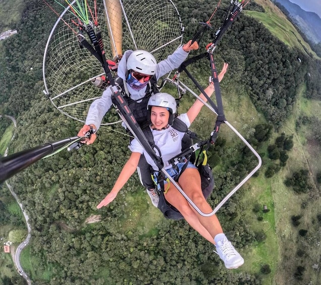 A person skydiving with a parachute, surrounded by a forested landscape. 2