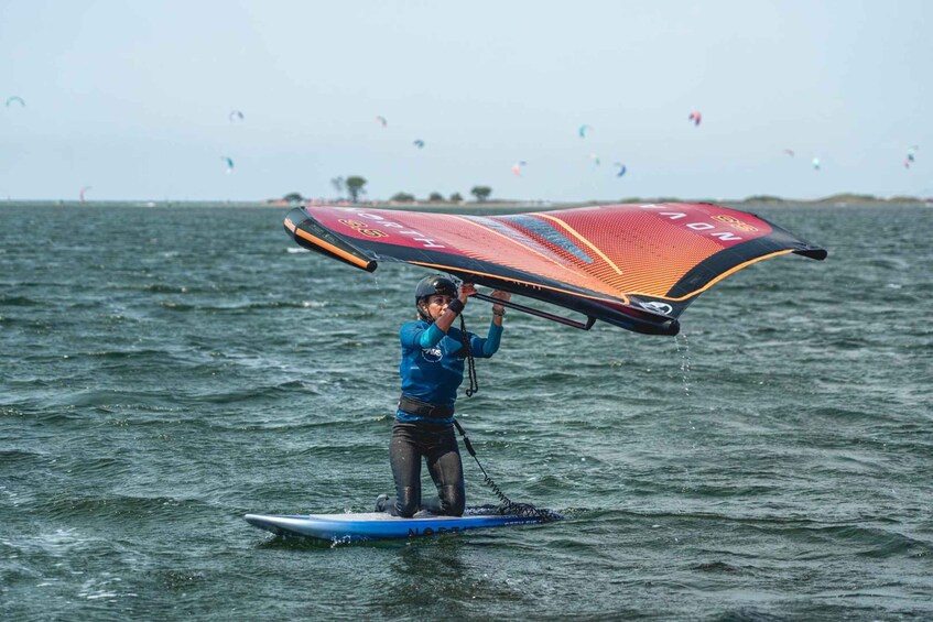 A person on a paddleboard with a kiteboard. 4