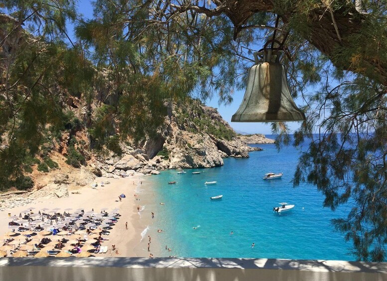 A beach with umbrellas, people, and boats. 1