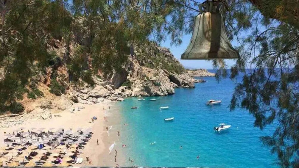 A coastal beach with clear blue waters, boats, and people sunbathing. 5