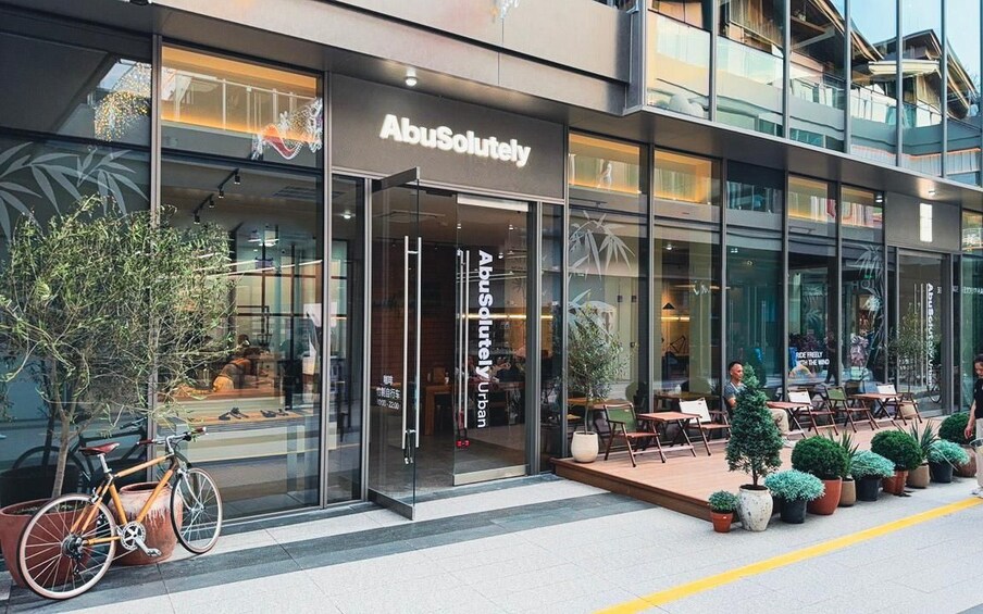 A modern building with a glass storefront labeled 'AbuSolutely.' 2