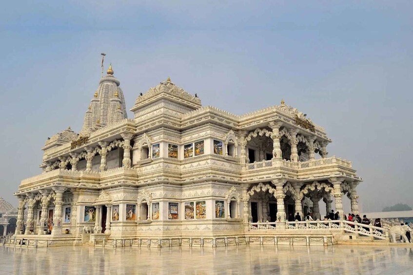 A white, intricately carved temple with multiple spires and detailed artwork. 1