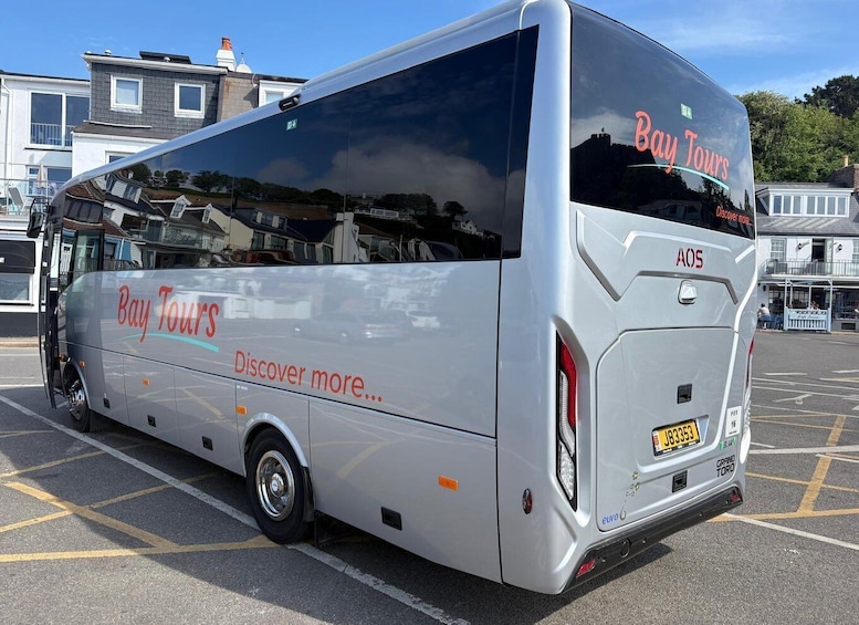 A silver bus with 'Bay Tours' branding parked in a lot. 2