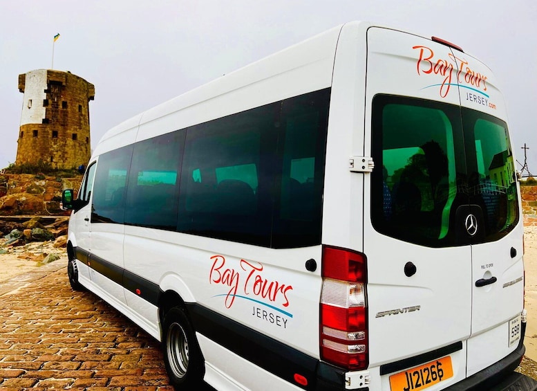 A white van with 'Bay Tours Jersey' branding parked on a cobblestone surface. 5
