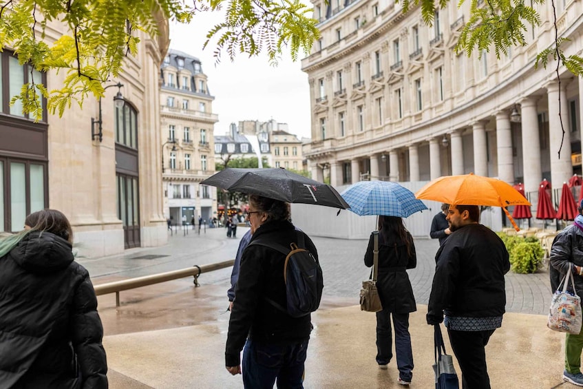 People walking on a wet street in a city with historic buildings. 4