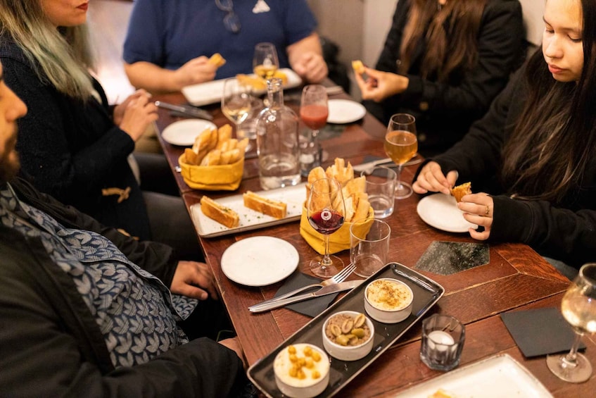 A group of people dining at a restaurant with various dishes and drinks on the table. 2