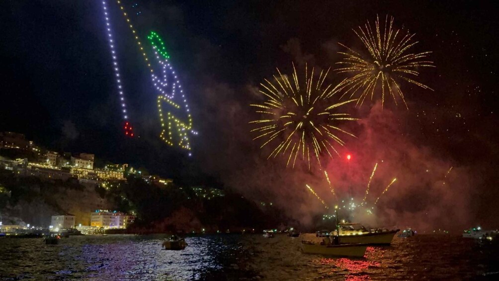 Fireworks over a coastal town with illuminated buildings. 4
