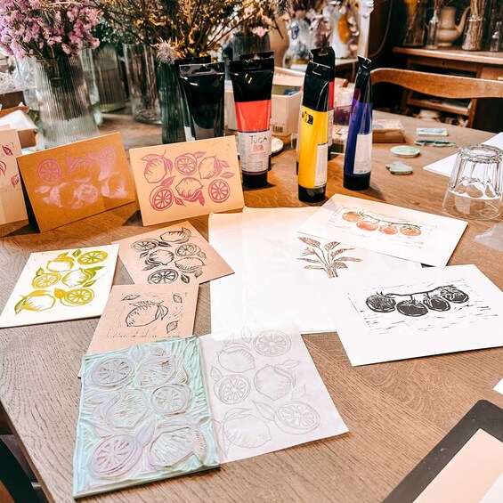 A table with various cards, some with citrus fruit designs, and bottles of ink. 1