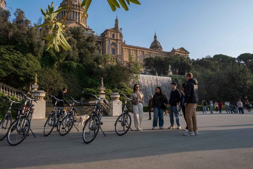 A park with a fountain, bicycles, and people walking. 2