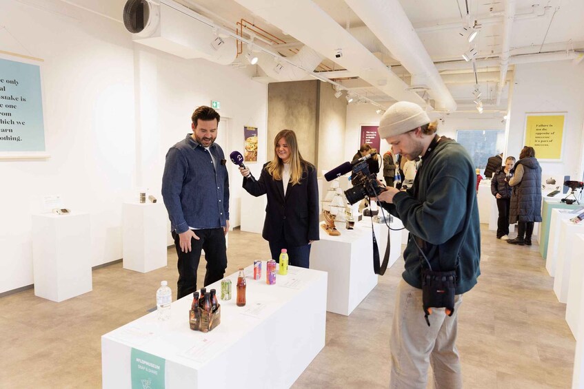 An indoor art gallery with white walls and a ceiling with exposed pipes. 5