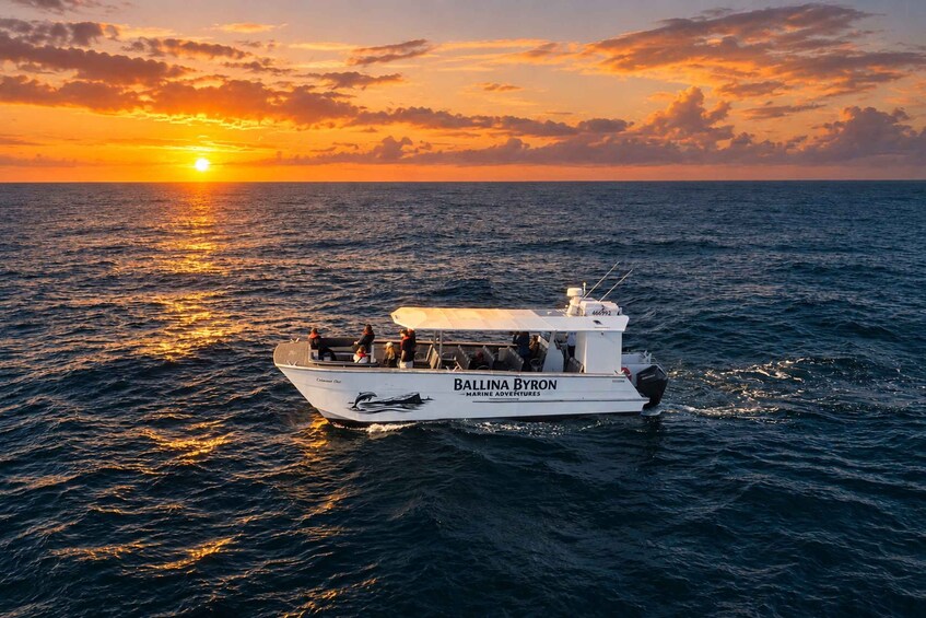 A boat named 'Ballina Byron' on the ocean during sunset. 3