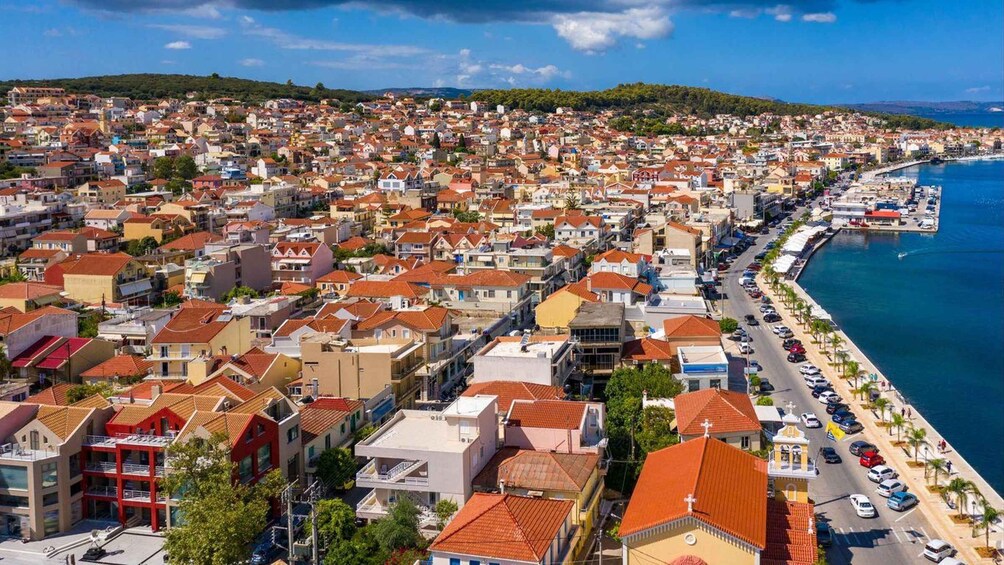 A coastal town with red-roofed buildings, a marina, and a clear blue sea. 2