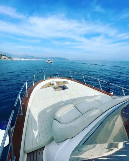 A boat's deck with a view of the sea and distant land. 4