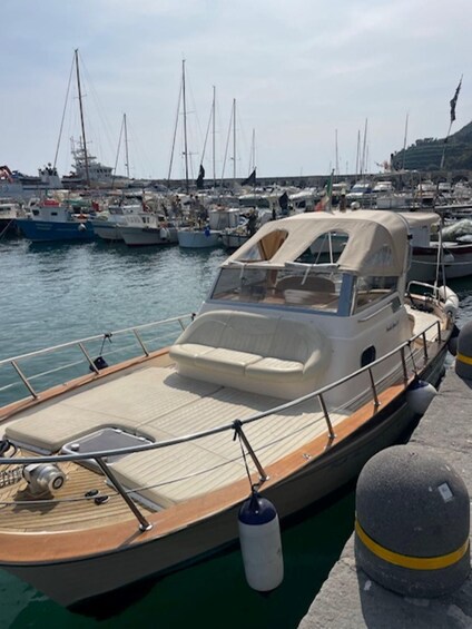 A boat docked at a marina with other boats in the background. 2