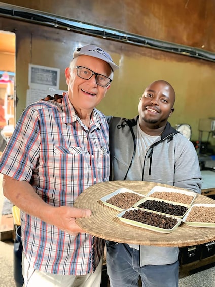 Two people holding a tray with different types of coffee beans. 3