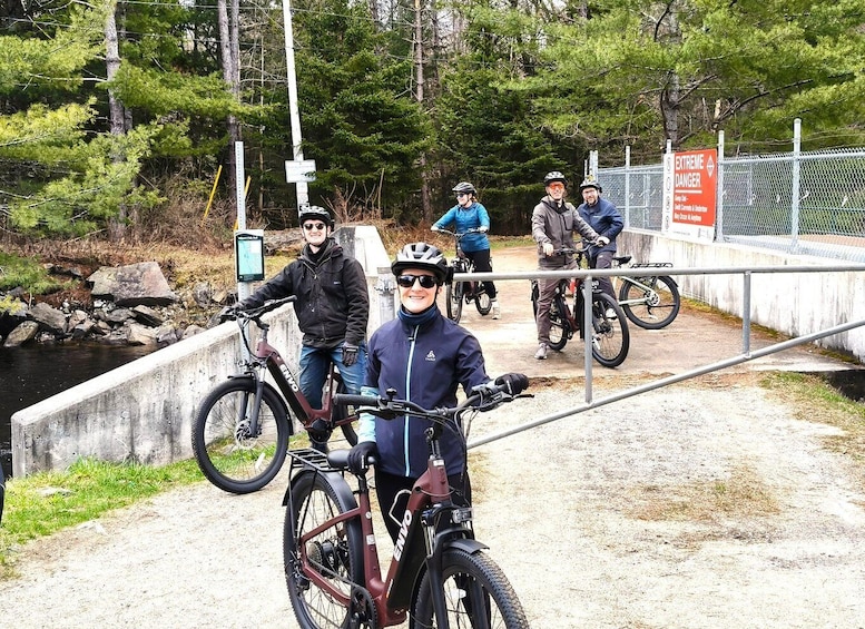 A group of cyclists on a dirt path with a warning sign indicating 'EXTREME DANGER.' 1