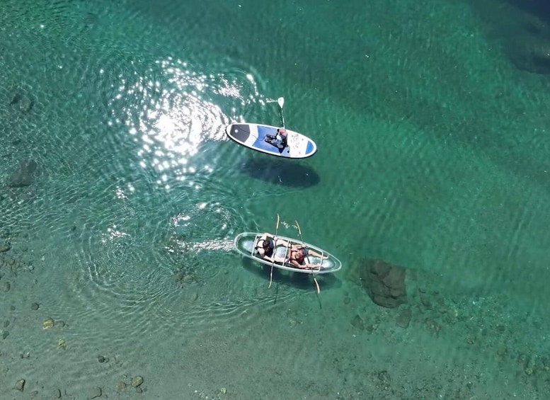 Two boats on clear water with visible rocks beneath. 1