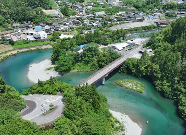 A river with a bridge, a parking area, and a residential area with houses. 5