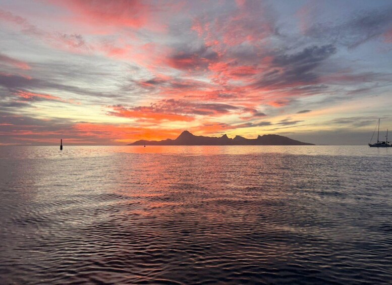 A sunset over a calm sea with a sailboat and a buoy. 1